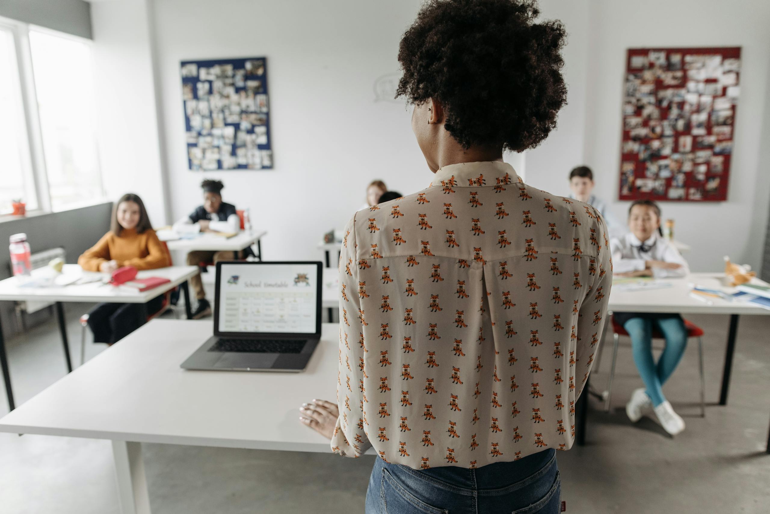 Female teacher engaging students in a classroom setting with diverse learners.