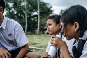 Group of cheerful children enjoying a lively outdoor school gathering in uniform.