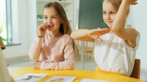 Two young girls happily engaging in educational activities at school, showcasing learning and joy.